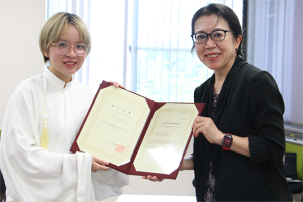 修了証書を手にする留学生（左）と坂東副機構長（右）