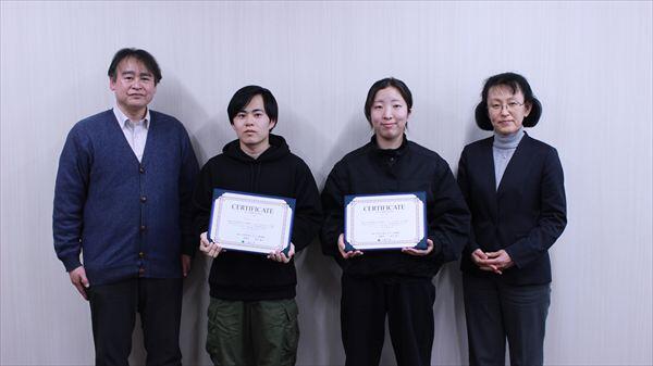 修了証を手にした学生2名と末原部門長（左）、湯浅機構長（右）