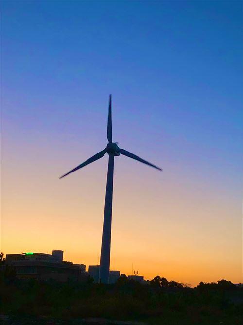 町屋海岸の裏から撮った夕暮れ時の風力発電と大学病院